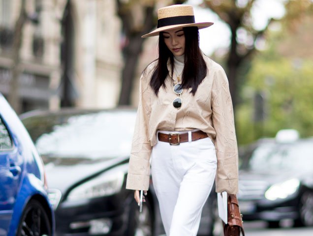 A showgoer at Paris Fashion Week wears a straw boater hat